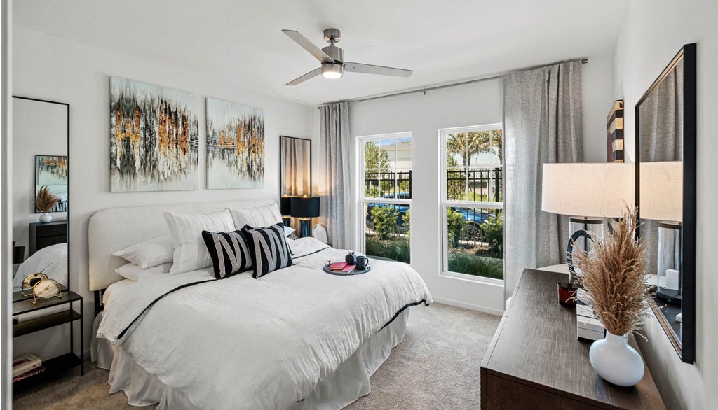 a bedroom with a large bed and a ceiling fan