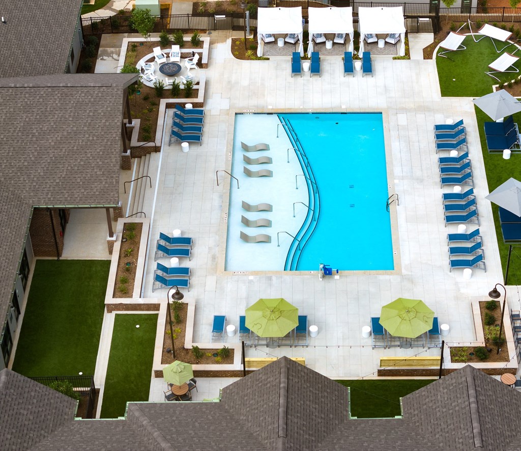 Belmont Apartments - Banks at Mt. Holly - Aerial View of Resort-Style Pool with Sunning Deck, Lounge Chairs, Umbrellas, Cabanas, and Firepit