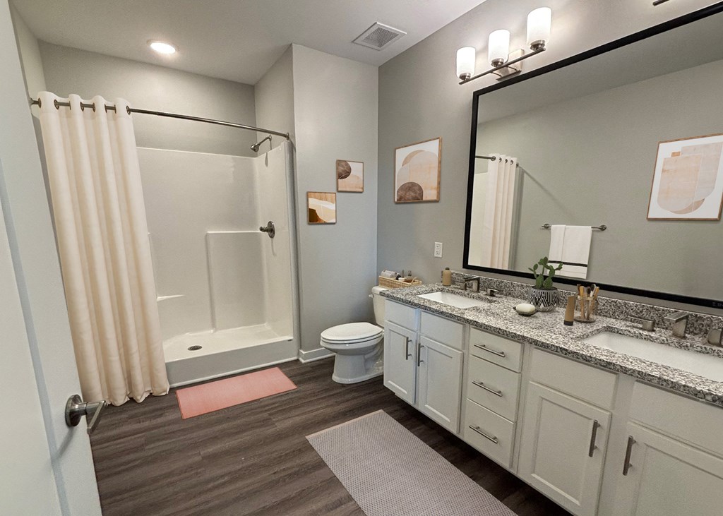 A bathroom with a toilet, sink, and shower.