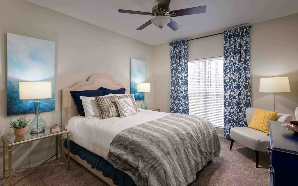 a bedroom with a large bed and a ceiling fan