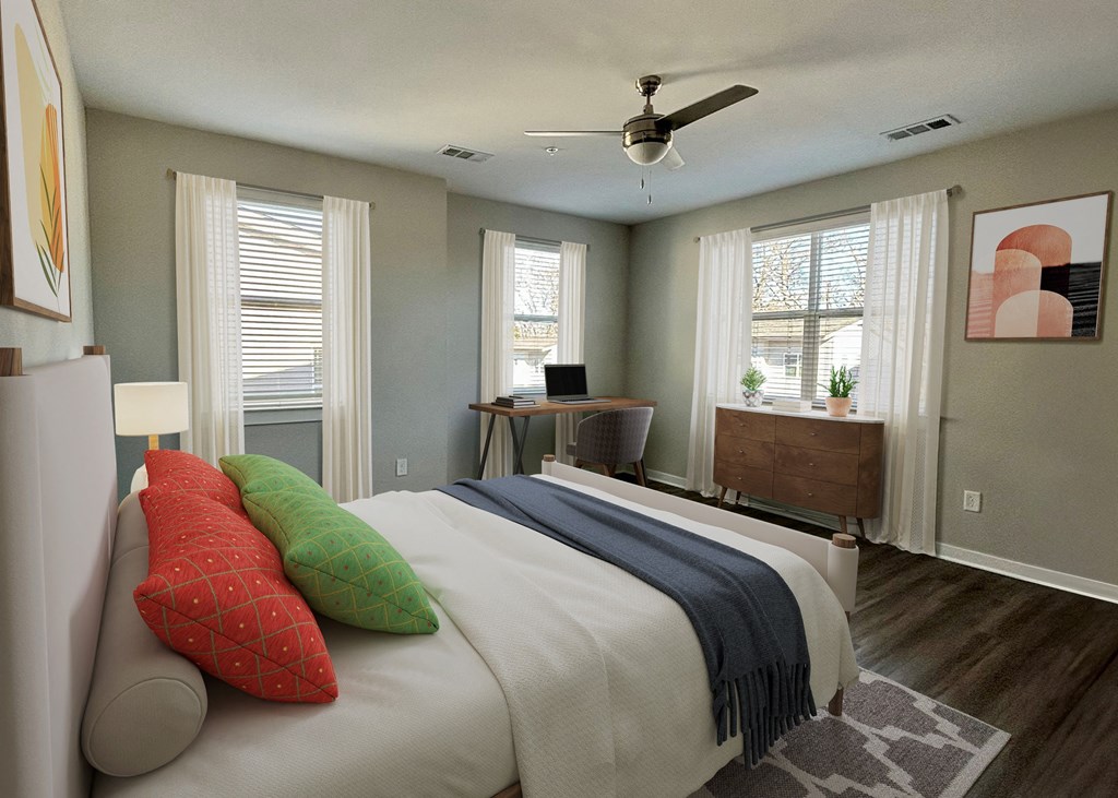 A bedroom with a large bed and a ceiling fan.