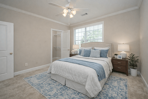 A bedroom with a large bed and a ceiling fan.