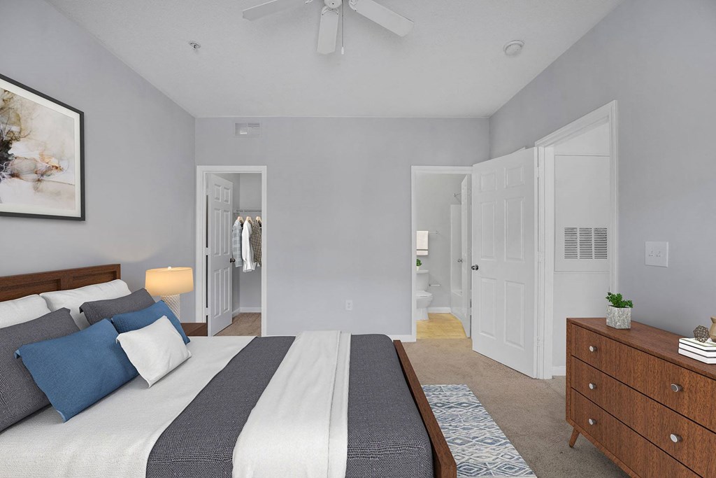A bedroom with a bed, dresser, and mirror.