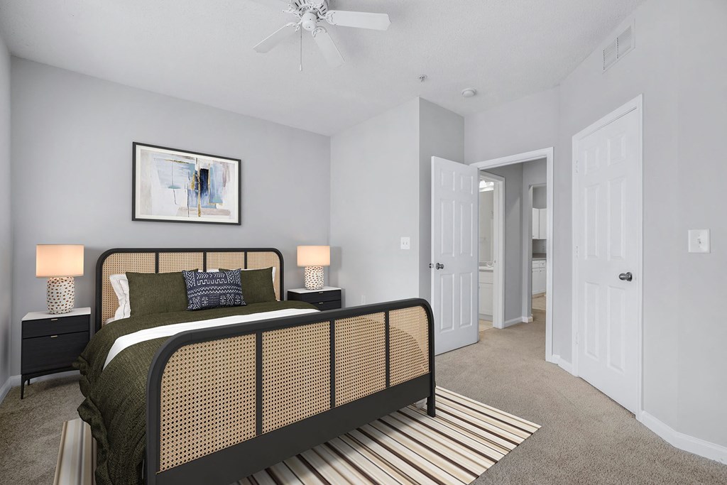 A bedroom with a bed, nightstands, and a painting on the wall.