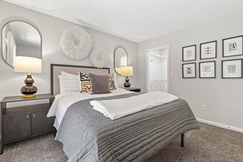 A bedroom with a large bed and two lamps.