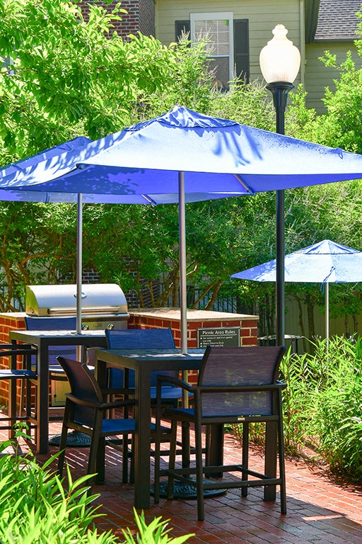 a table and chairs with umbrellas on a patio