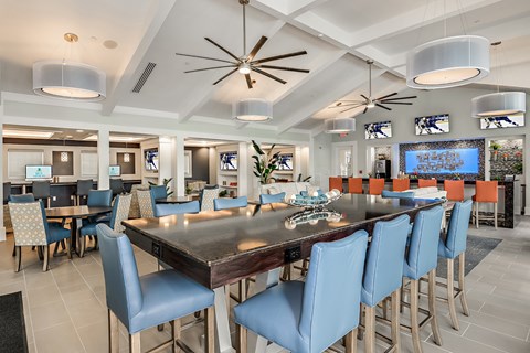 A large dining room with a long table and blue chairs.