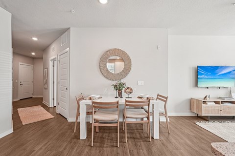 A dining room with a wooden table and chairs.