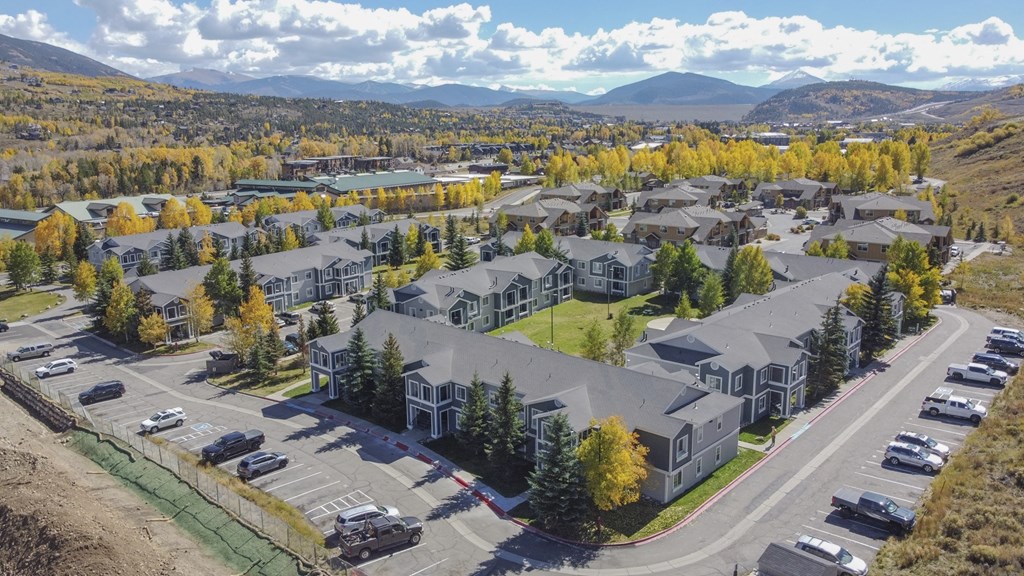an aerial view of a neighborhood of houses with cars parked in front of them