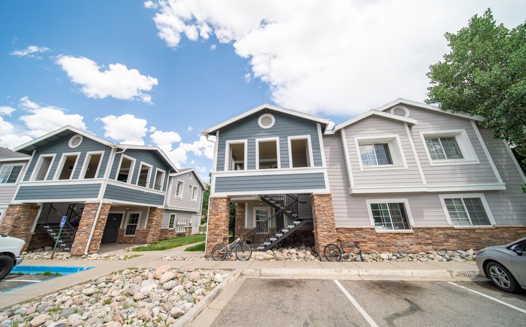 a row of houses with cars parked in front of them