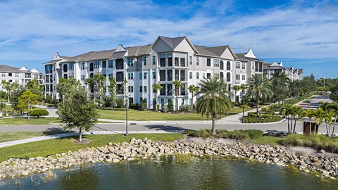 A large, modern building with a pond in front.