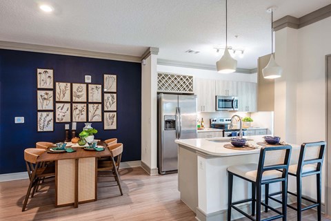 A kitchen with a dining table and chairs.