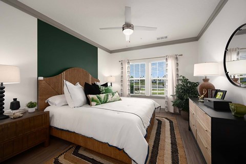 A bedroom with a large bed and a ceiling fan.