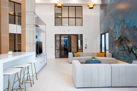 A modern living room with a white sofa and a bar area.