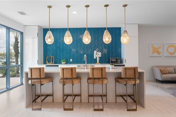 A kitchen with a blue backsplash and wooden bar stools.