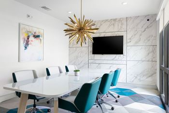 A conference room with a white table and blue chairs.