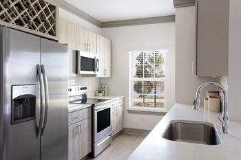 A modern kitchen with a stainless steel refrigerator and a microwave above the stove.