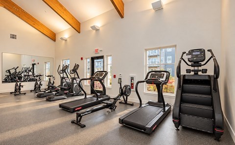 A gym with treadmills, elliptical machines, and exercise bikes.