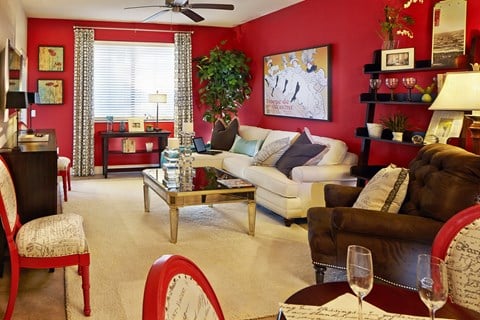 a living room with red walls and white furniture