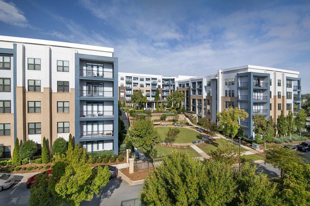 A large apartment complex with a parking lot in front.