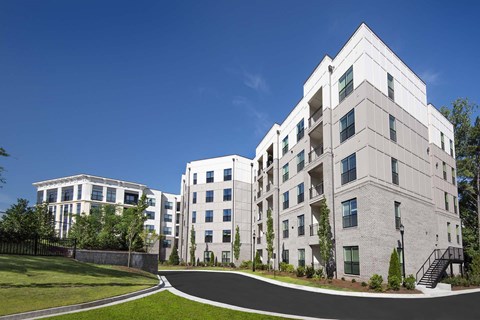 A modern apartment complex with white buildings and green lawns.