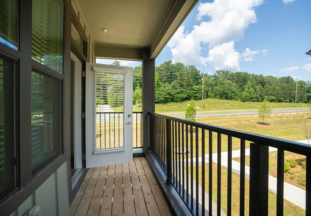 a covered porch with a view of a field and a door