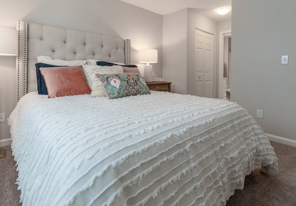 a bedroom with a large white bed and pillows
