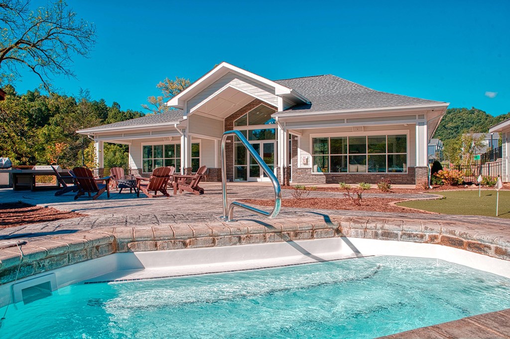 A house with a pool in front of it.