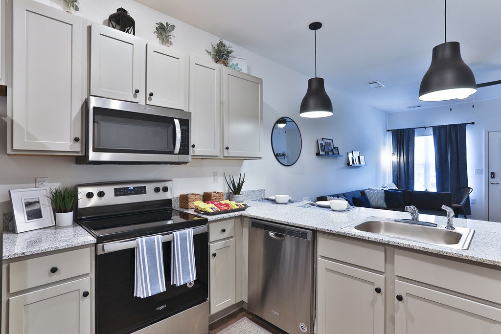 A kitchen with a black oven and white cabinets.