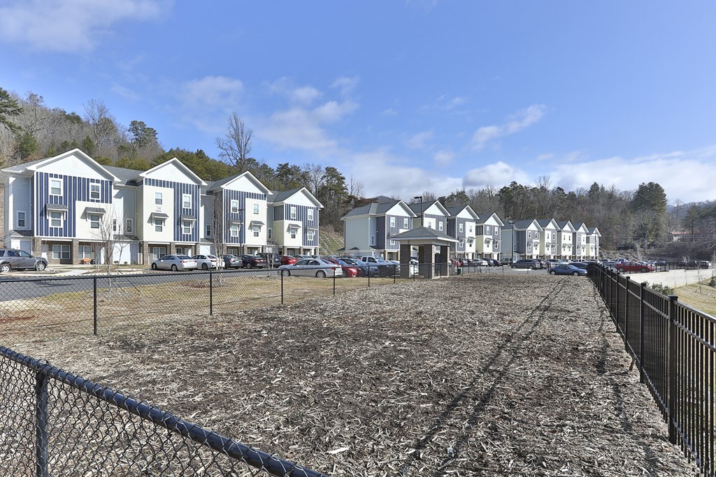 A row of houses with a fence in front.