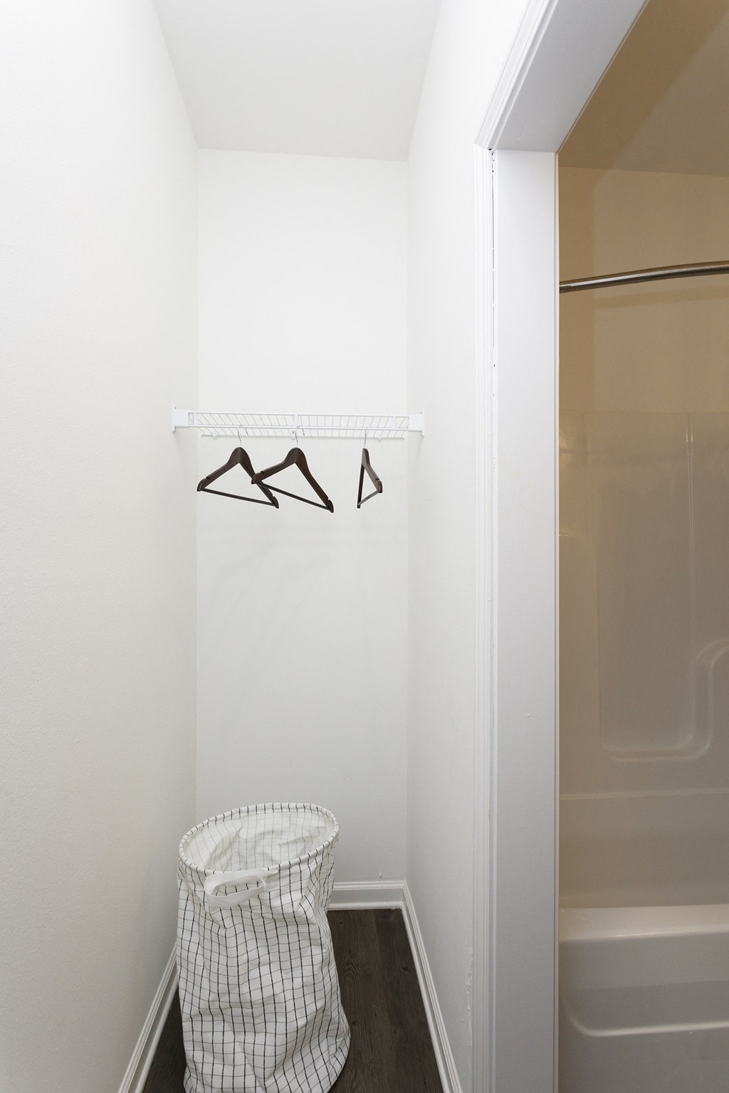 A white bag is sitting on the floor next to a white wall.