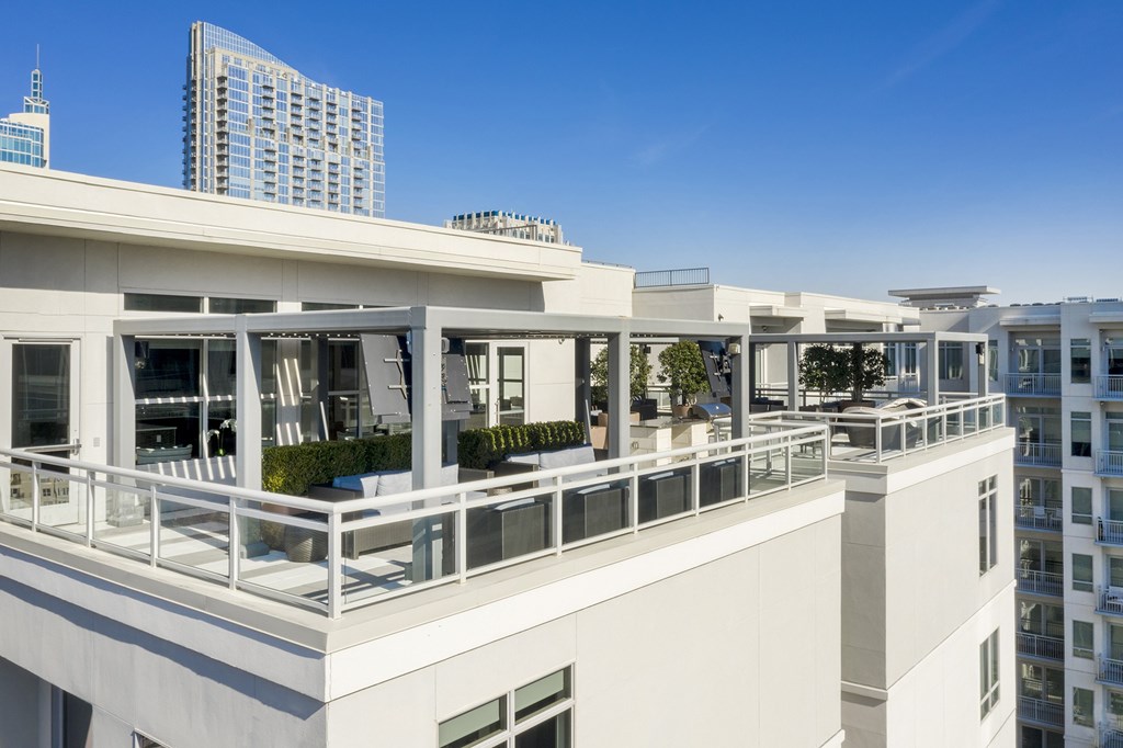 A white building with balconies overlooks a cityscape.