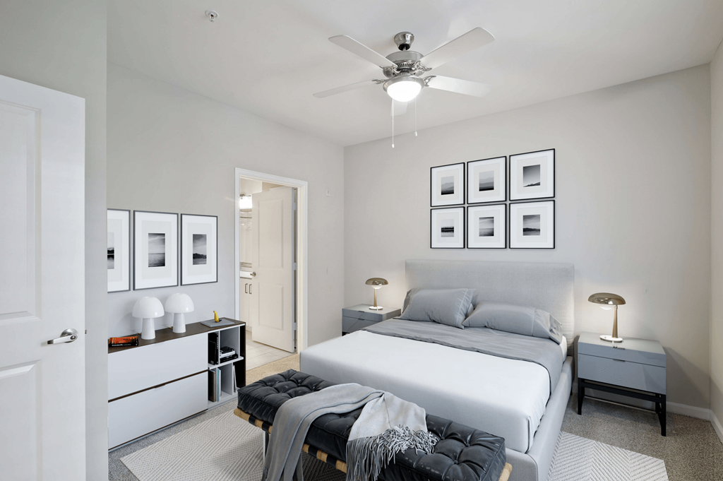 A bedroom with a bed, nightstands, and pictures on the wall.