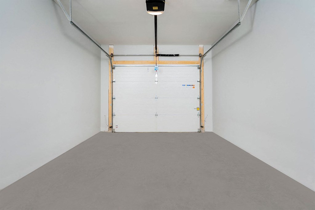 A white room with a grey floor and a white door.