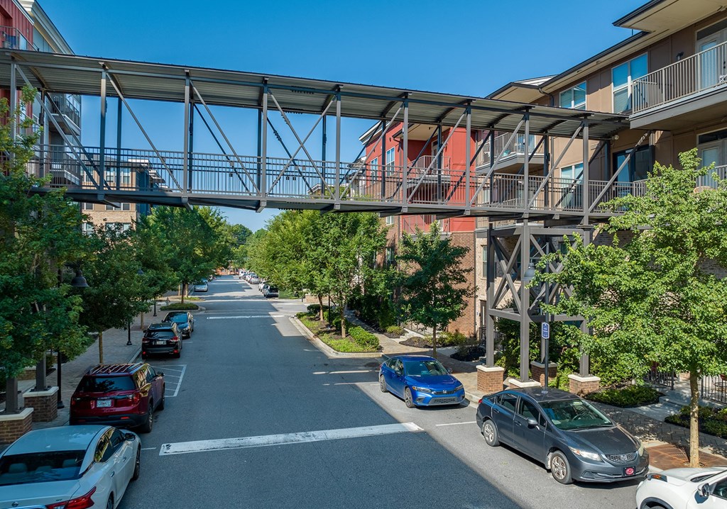 a bridge over a street with cars parked under it