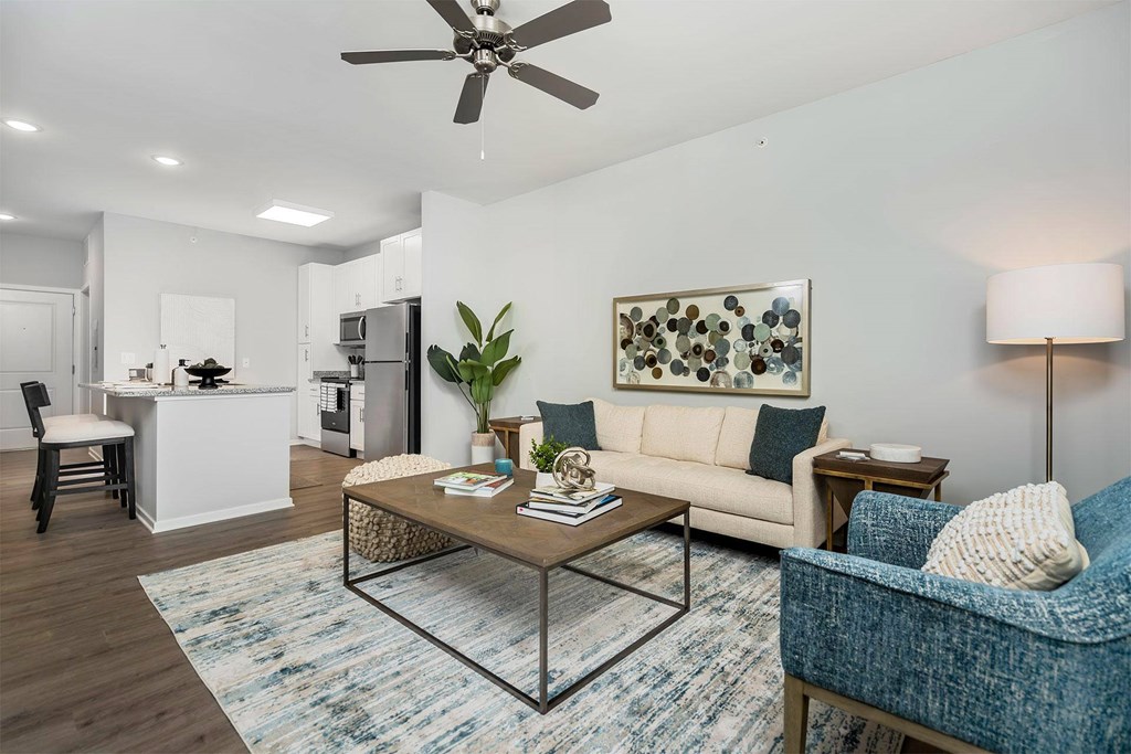 A living room with a white couch, a coffee table, and a ceiling fan.
