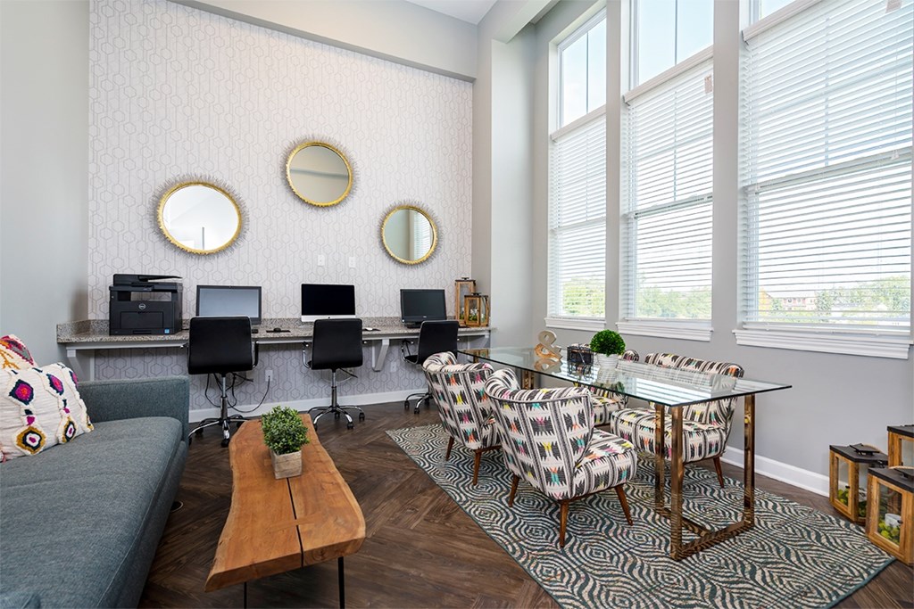 A modern living room with a grey couch, a glass table, and a patterned chair.