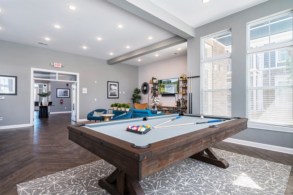 A pool table in a room with a view of the city.