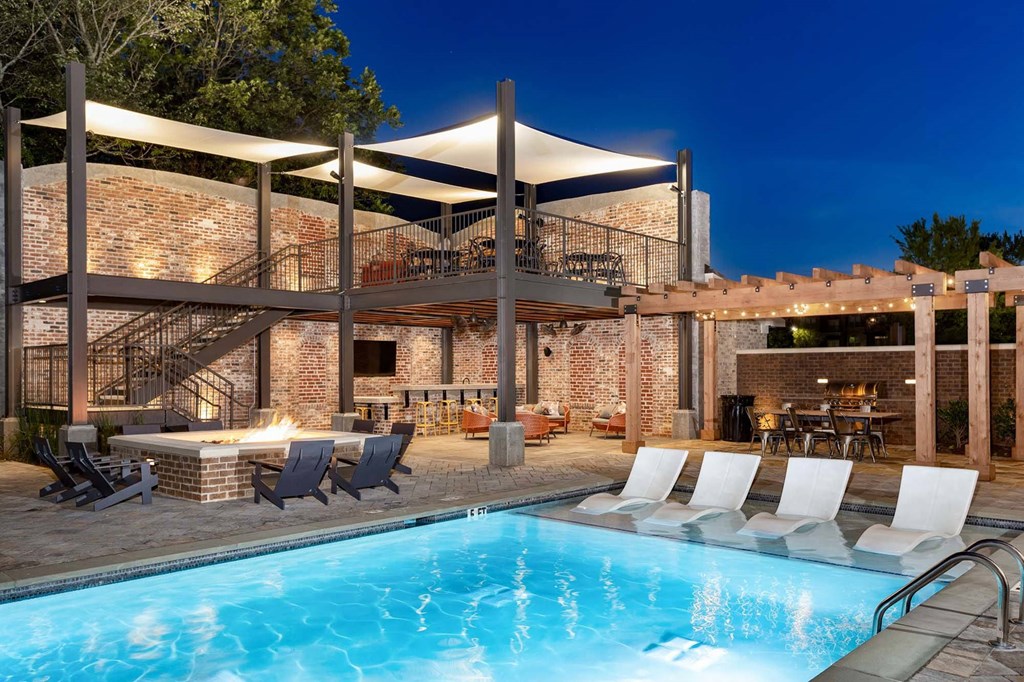 a swimming pool at a resort with a poolside bar and patio furniture