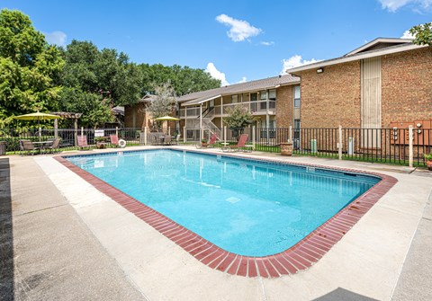 A swimming pool surrounded by a fence and trees.