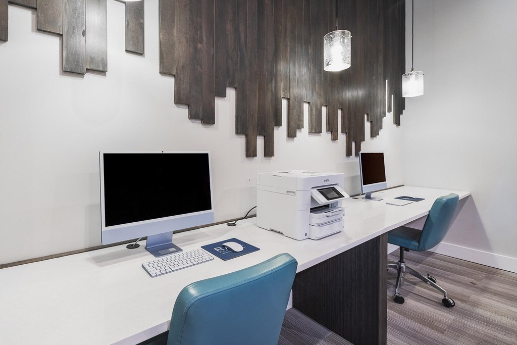 A modern office with a white desk and a blue chair.