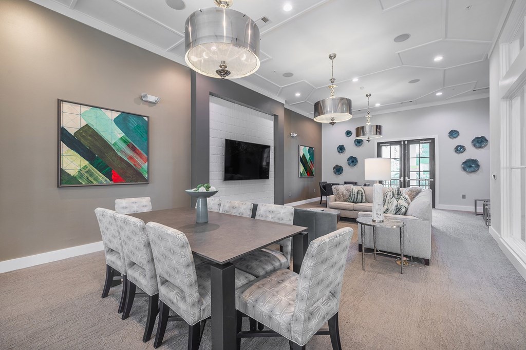 A modern dining room with a large table and chairs.