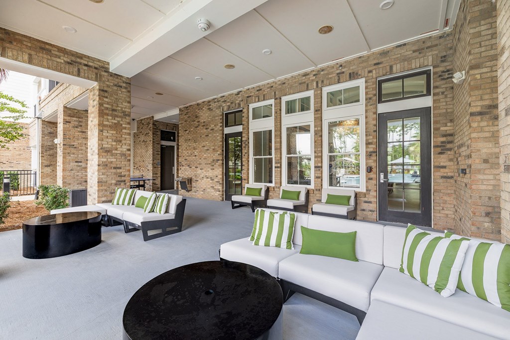 A living room with a white couch and green pillows.