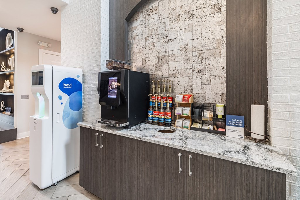 A white and blue vending machine sits next to a counter with a variety of items on it.
