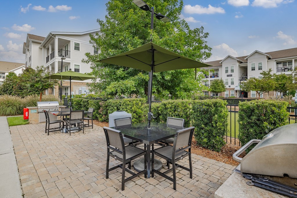 A patio with a table and chairs under an umbrella.