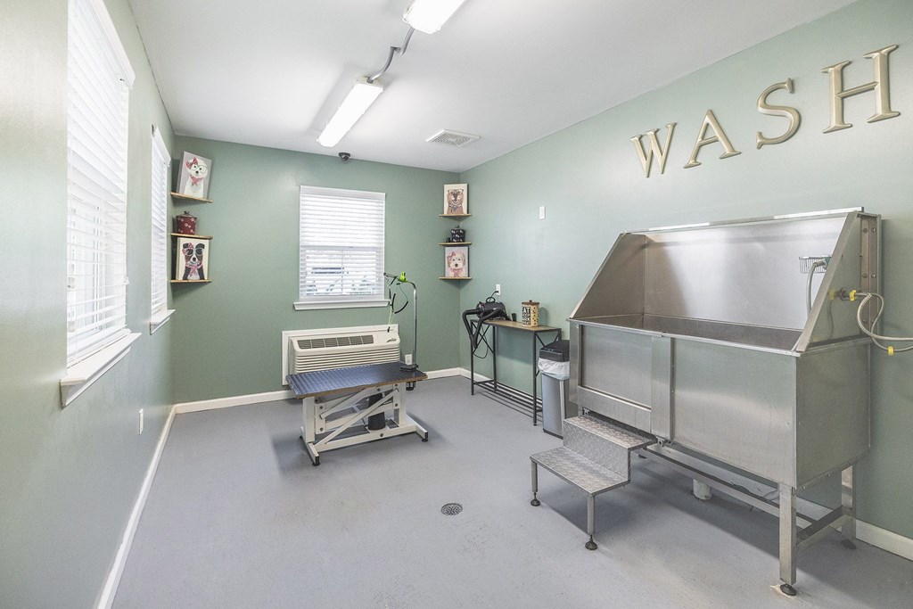 A room with a wash sign on the wall and a couple of sinks.