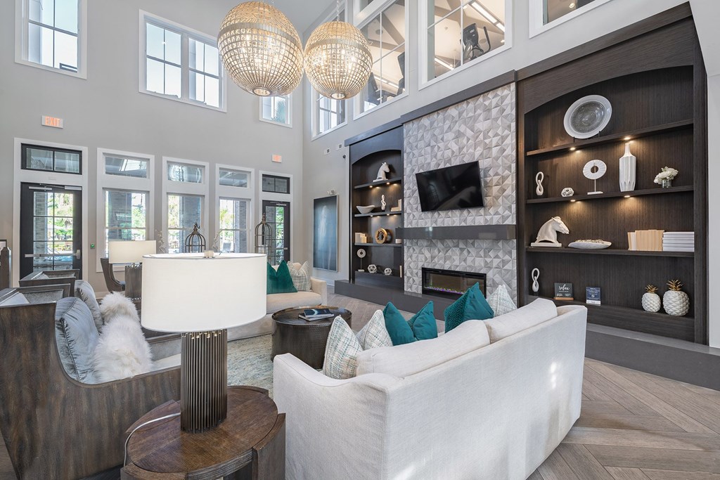 A modern living room with a white couch and a fireplace.