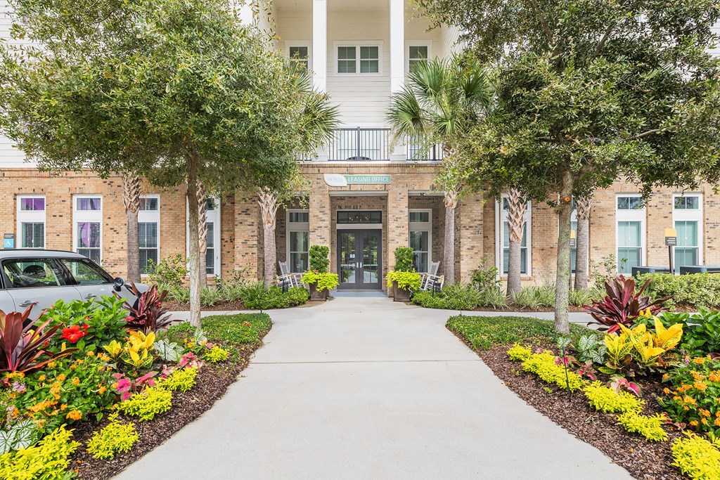 A white building with a car parked in front of it.