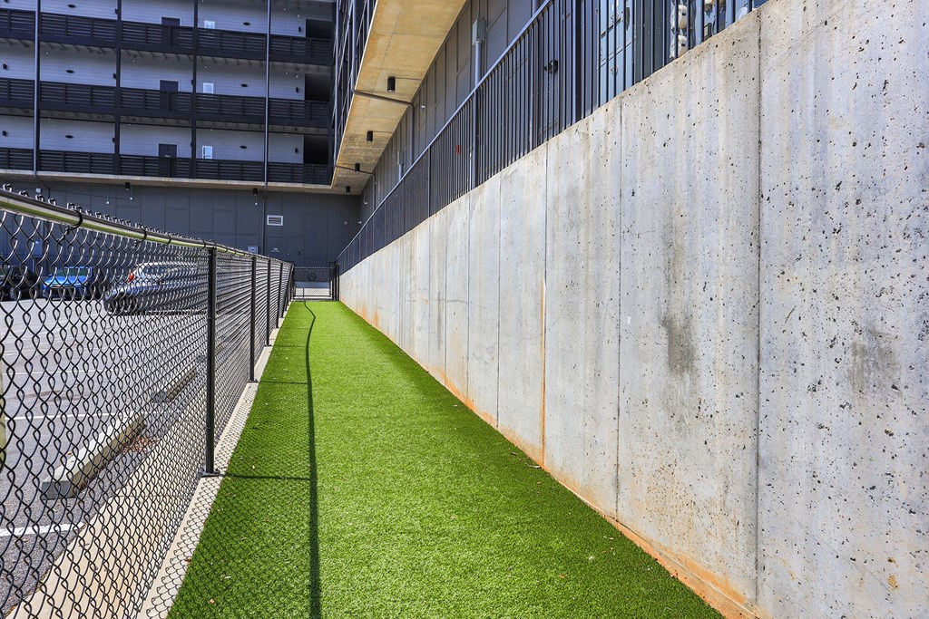 A long concrete wall with a green grassy area in the middle.