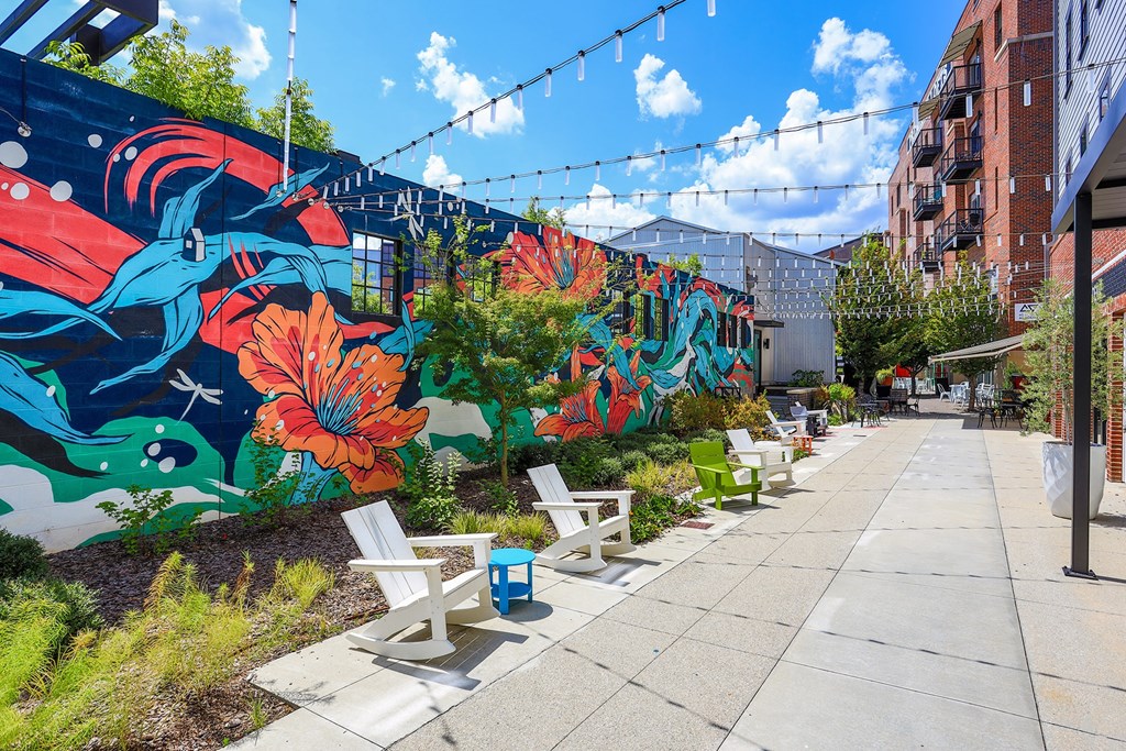 A colorful mural on a wall with a bench in front of it.